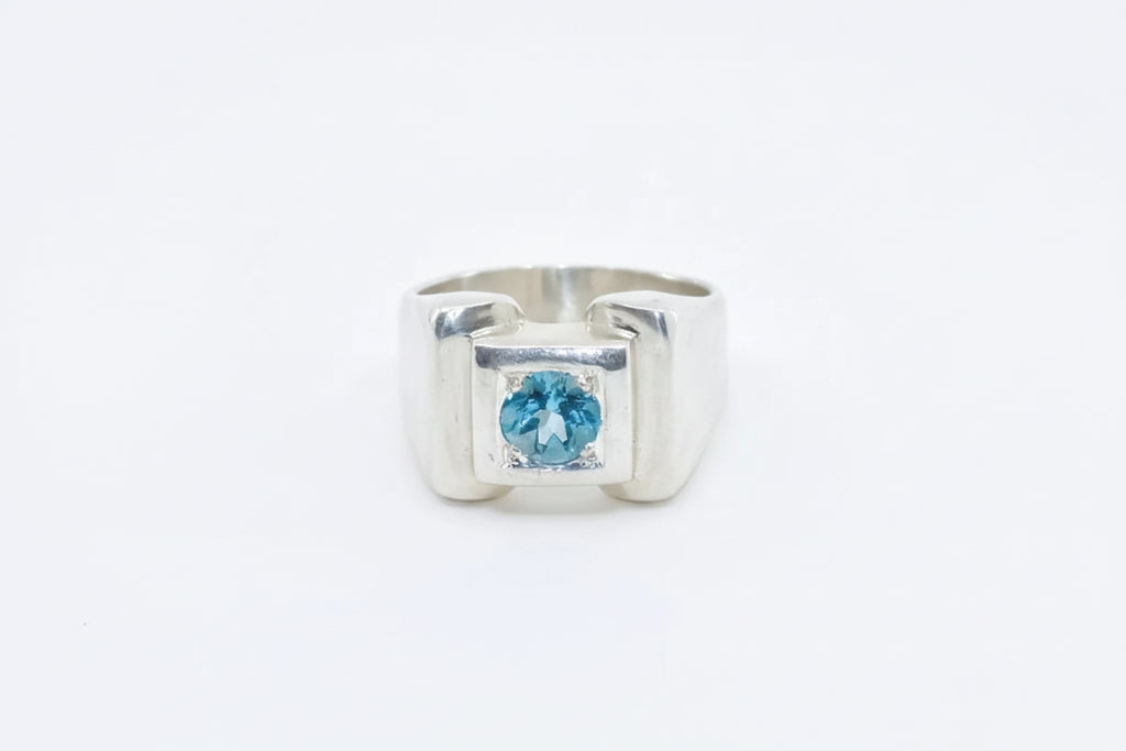 Silver ring with a blue gemstone on a white background