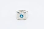Silver ring with a blue gemstone on a white background