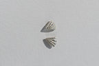 Pair of silver shell-shaped earrings on a light gray background